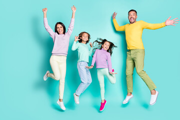 Photo portrait of full family jumping up together isolated on vivid turquoise colored background
