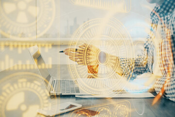 Technology theme hologram with man working on computer on background. High tech concept. Double exposure.