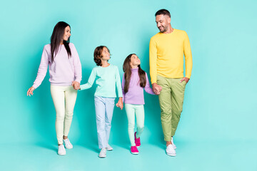 Fototapeta premium Photo portrait of big family with little kids holding hands children looking at father isolated on vivid teal colored background