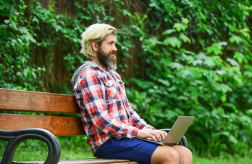 Remote job. Online shopping. Agile business. Bearded guy sit bench park nature background. Work and relax. Working online. Hipster inspired work in park. Fresh air. Mobile internet. Modern laptop