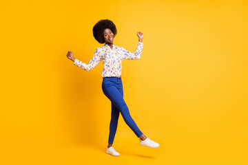 Full length photo of adorable lucky dark skin woman wear casual outfit rising fists isolated yellow color background