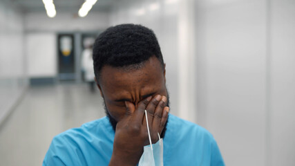 Young african man surgeon tired after operation in hospital