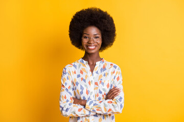 Photo of charming confident dark skin woman wear casual outfit arms crossed spectacles isolated yellow color background