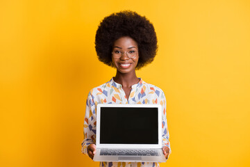 Photo of sweet charming dark skin woman wear casual outfit holding modern device empty space isolated yellow color background