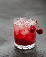 Cold alcoholic cocktail with cherry and ice cubes. Cherry Cocktail with Vodka. Selective focus