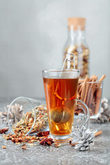 Herbal tea with spices on a grey background.