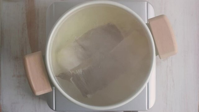 Cod fish boiling in water on the pot