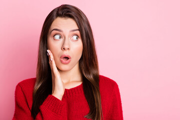 Photo portrait of surprised astonished girl looking at side with opened mouth touching face wearing red casual clothes isolated on pink color background