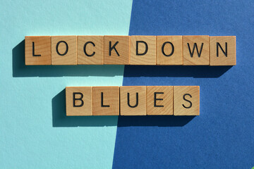 Lockdown Blues, words in wood alphabet letters isolated on blue background.