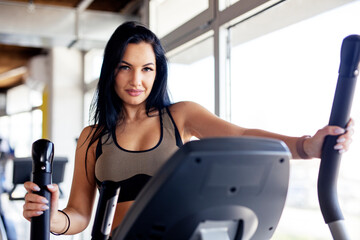 Fototapeta premium Fit long dark hair woman exercise at the gym wearing sportwear
