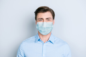 Close-up portrait of nice content guy wearing safety gauze mask influenza risk prevention isolated on gray color background