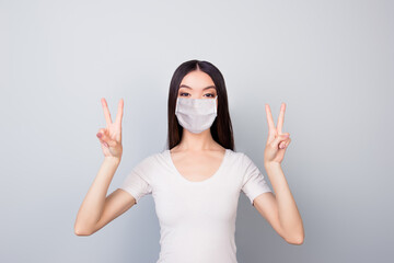 Portrait of nice funky youth girl wearing safety mask showing double v-sign mers cov prevention...