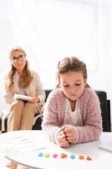girl patient calculating with figures while visiting psychologist, stock image
