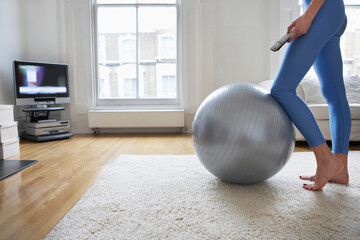Woman By Fitness Ball Watching Television