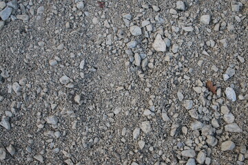 Close up of type 1 mortar base crushed concrete stones with some brick granite gravel mix on ground in garden landscape for build of constructing wooden shed base 