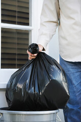 Hand Putting Garbage Bag Into Trash Can