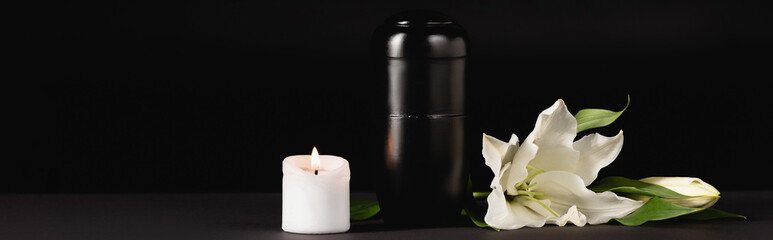 lily, candle and urn with ashes on black , funeral concept, banner