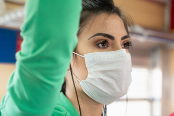 Close up of woman using public transport in the city. Girl wearing mask to travel the city by train.