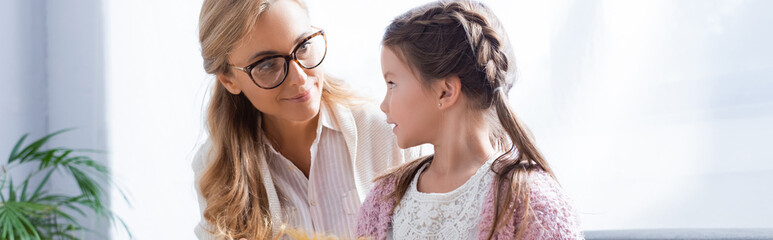 little girl patient talking to blonde woman psychologist, 
