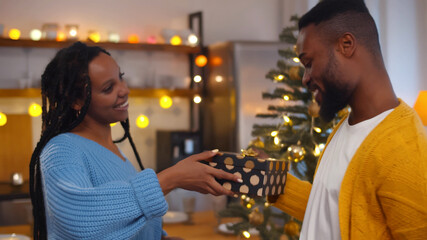 Husband and wife affectionately exchanging christmas gifts