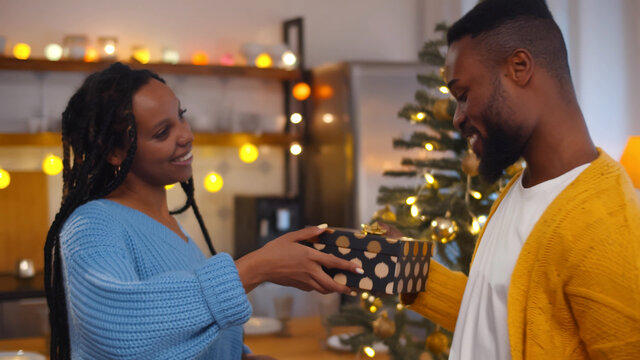 Husband and wife affectionately exchanging christmas gifts - Powered by Adobe