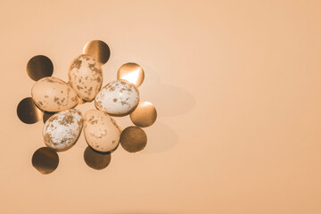 peach and white Easter eggs painted with gold with round golden confetti