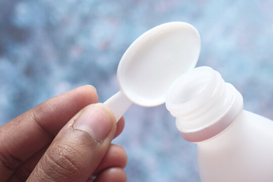 pouring liquid medicine onto a spoon top view 
