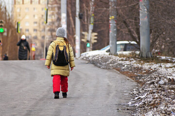 Fototapeta na wymiar A girl goes to school on the city sidewalk