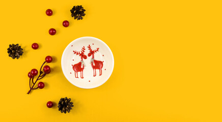 Decorations composition, plate with deer, decoration of berries and corns, orange background with copy space, banner