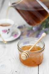 Miód w misce i nalewanie herbaty © andsko