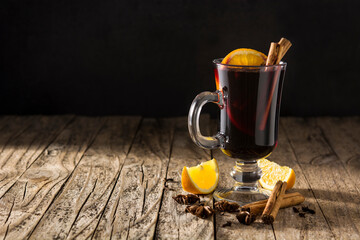 Fototapeta na wymiar Traditional mulled wine with spices on rustic wooden table.Copy space
