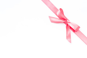 Pink ribbon with bow for holiday gift box or greeting card banner. Top view