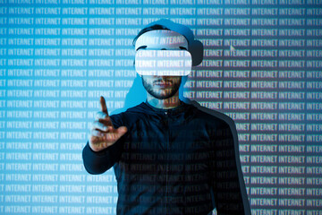 Young man in futuristic costume on blue neon light digital interface background. Guy using VR...