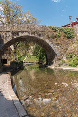 Vertical shot of an old bridge over the river in Potes, Cantabria, Spain