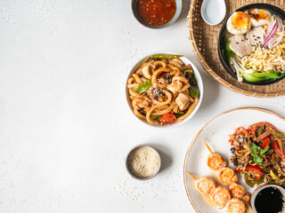 Set asian food - ramen soup, grilled shrimp, stir fry vegetables and udon with seafood