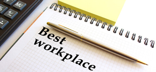 Fototapeta premium Notepad with text BEST WORKPLACE, next to it lies a calculator. Business concept.