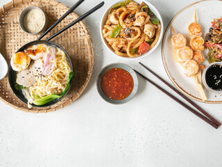 Set asian food - ramen soup, grilled shrimp, stir fry vegetables and udon with seafood