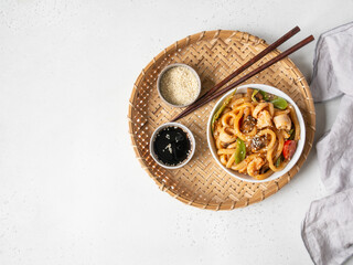 Udon noodles with seafood and vegetables cooked in a wok