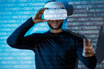 Young man in futuristic costume on blue neon light digital interface background. Guy using VR helmet. Augmented reality, virtual reality, future technology, game concept.