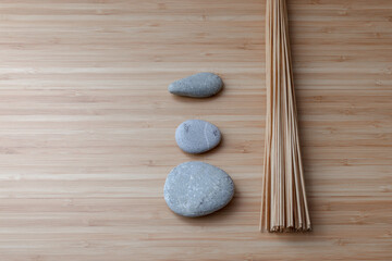 Bamboo massager and sea stones. Flat lay. Minimalism. Bath accessories on bamboo. Selfcare.