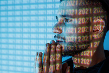 Young man with beard. Portrait of guy on blue neon light digital interface background. High fashion model posing in studio.