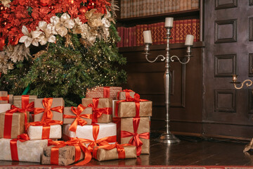 Beautiful Christmas gift boxes on floor near fir tree in room