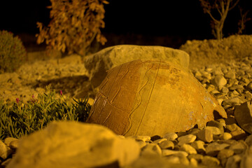 vessels in ocher tones in a garden at night