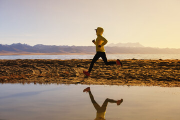 Woman trail runner cross country running  in winter lakeside