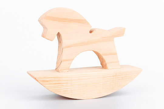Wooden rocking horse on a gray background. Crafting from wood. Close-up.