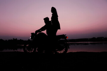 Fototapeta na wymiar silhouette of a couple on a motobike