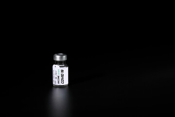 Covid 19 vaccine bottle with black background