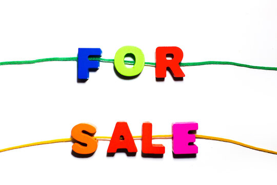 For sale word text written from wooden colorful painted abc letters with holes, strung on a lace, shopping buying, selling concept