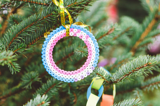 Handmade plastic beads corcle decoration on Christmas tree. Diy ideas for children. Environment, recycle, upcycling and zero waste concept. Selective focus, copy space