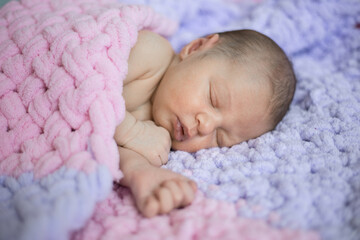 Newborn baby sleeping sweetly in a pink blanket